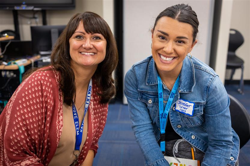 A PTO president smiles while sitting next to a school principal